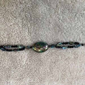 Beaded bracelet featuring abalone shell nuggets, black beads, and a toggle clasp